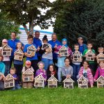 Kinder und Helfer mit Insektenhotel